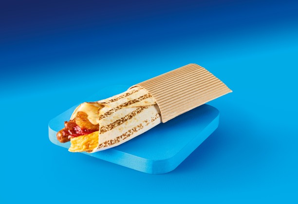 A delicious breakfast wrap featuring sausage, egg, and bacon, resting on a blue background, highlighting its appeal.