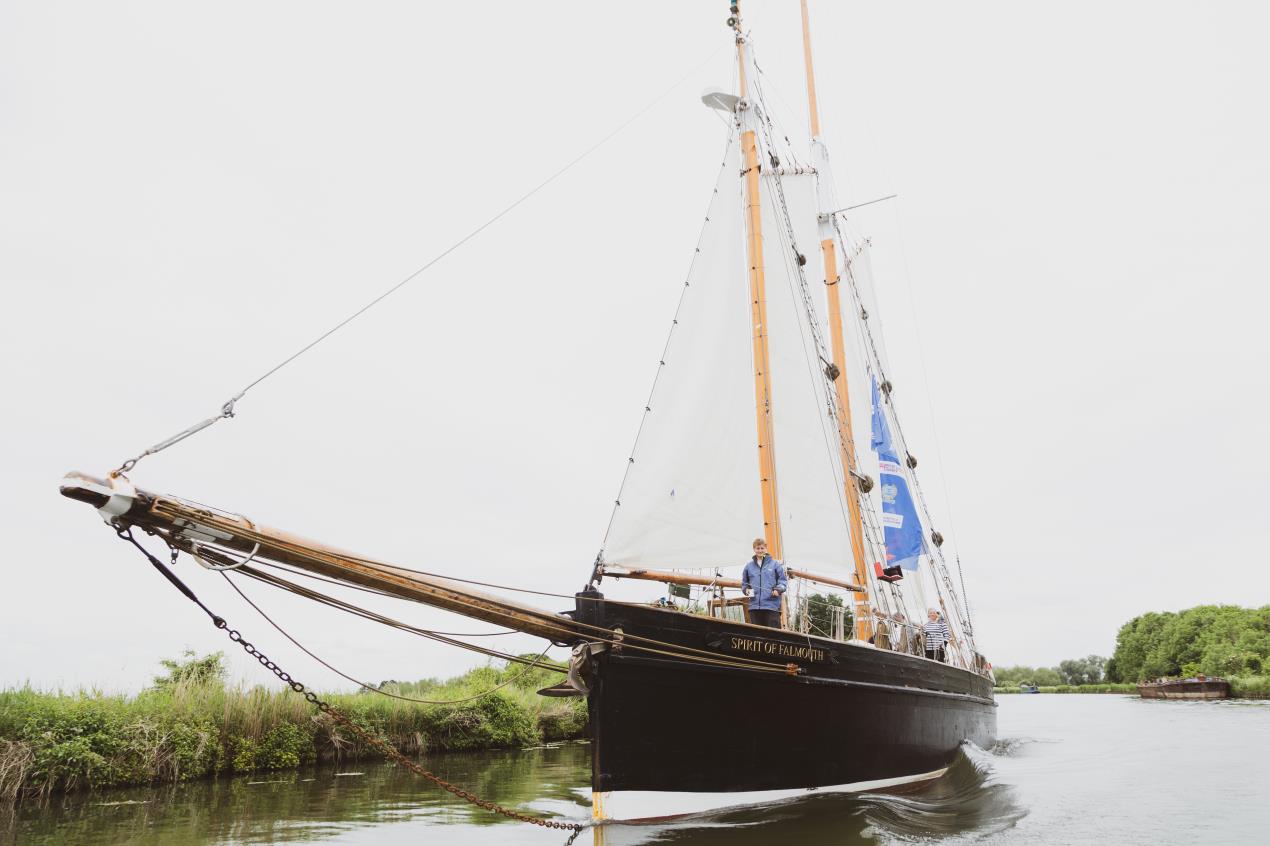 Tall ship "Spirit of Hull" sailing on calm waters, surrounded by lush greenery and a cloudy sky in Hull, Yorkshire.