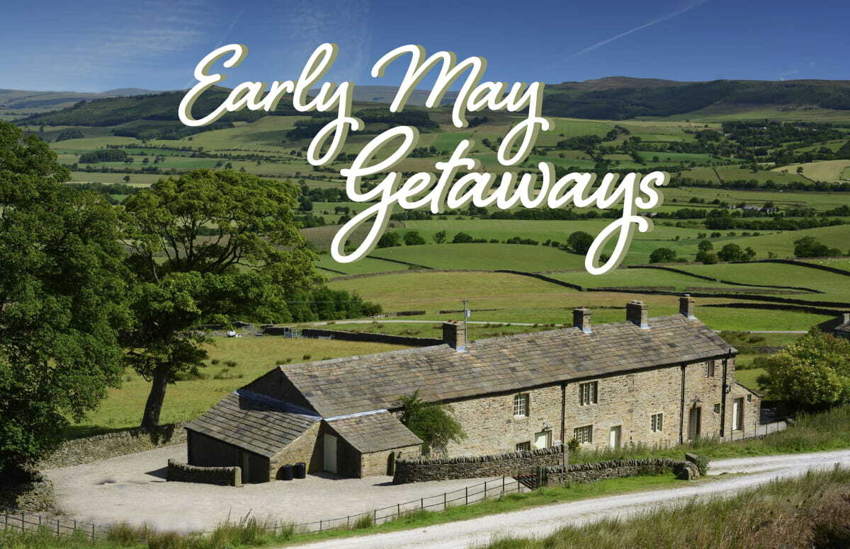 Charming stone cottage nestled in lush green hills of Yorkshire, surrounded by rolling fields under a clear blue sky.