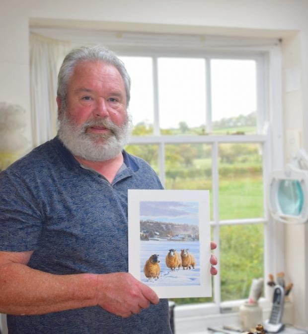 A man with a white beard holds an art piece featuring four birds in a snowy landscape, with a green field visible outside.